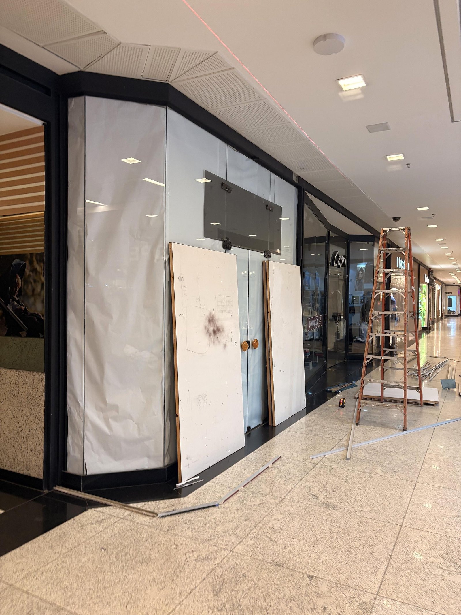 Loja da Bio Mundo fechada com painéis brancos antes do adesivo, no Colinas Shopping